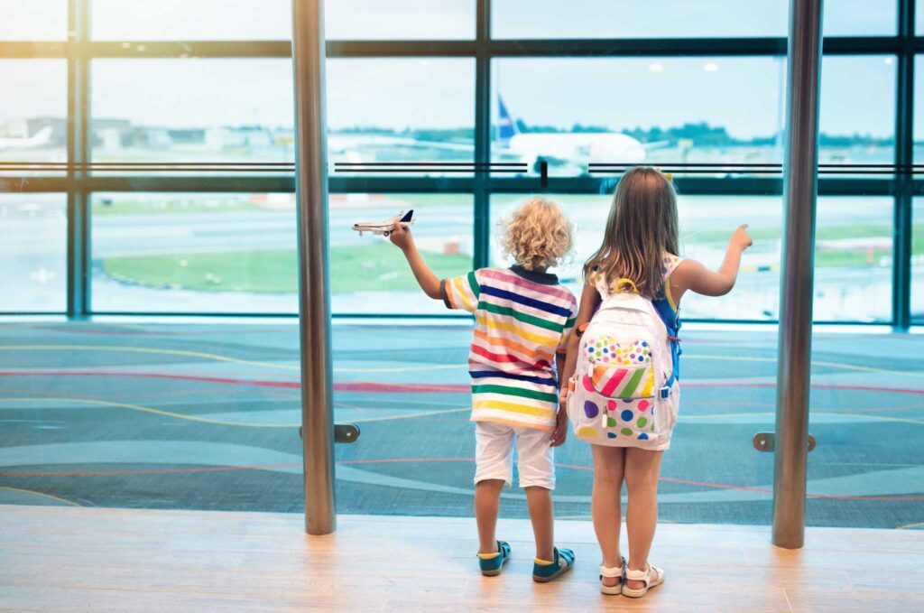 deux enfants à l'aéroport, un garçon avec un jouet en forme d'avion pour s'occuper dans les transpors