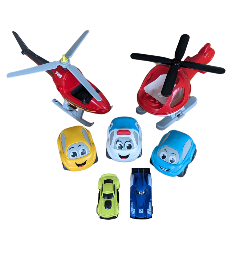 image avec des jouets : 3 petites voitures pour enfant (verte, blanche et bleue) et 2 hélicoptères rouges. Idéal pour jouer dans les transports.