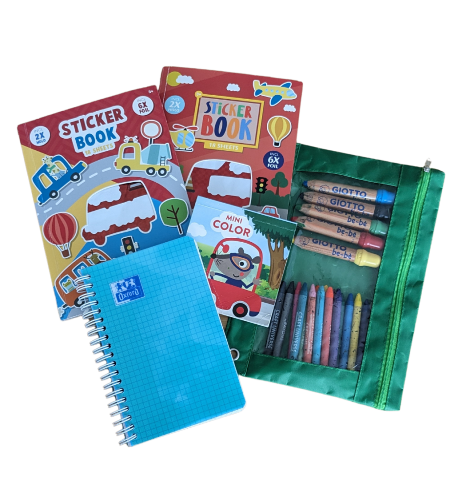 Deux livres de stickers véhicules avec un mini carnet de coloriages, un petit carnet bleu et une trousse verte avec des crayons de couleurs pour enfant. Pratique à utiliser dans les transports.